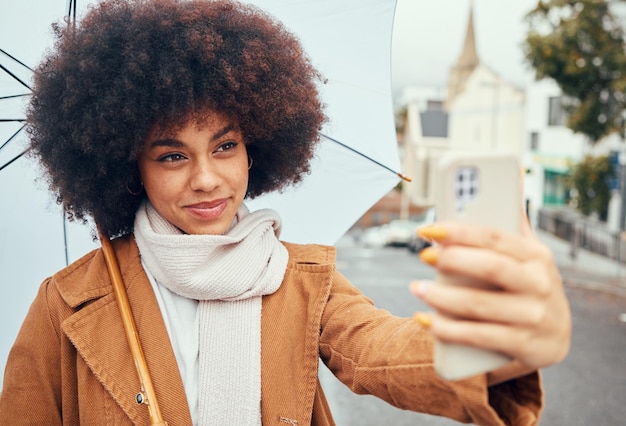 Reisvrouw of telefoon selfie met paraplu in New York City op sociale media review videogesprek of live streaming op content creator vlog Happy smile of afro influencer op vlogger mobiele technologie