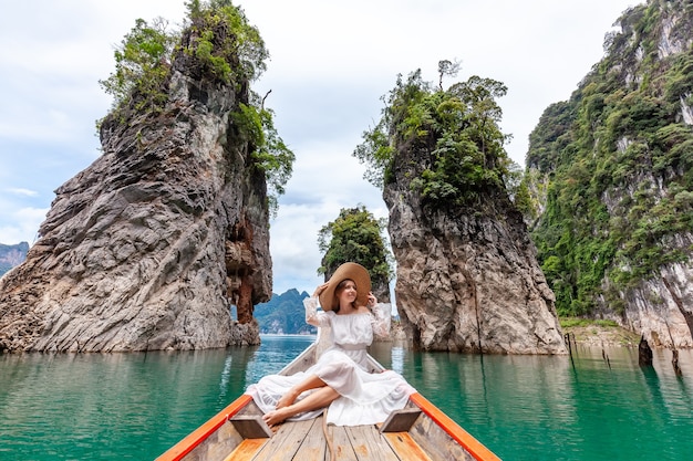 Reisvrouw zittend op een boot in de buurt van beroemde drie rotsen in khao sok park thailand