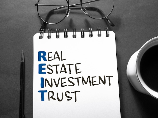 REIT Real Estate Investment Trust text words typography written on book against dark background