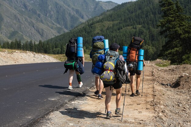 Foto reizen lifestyle en survival concept toeristen met rugzak gaan langs het pad naar de bergen