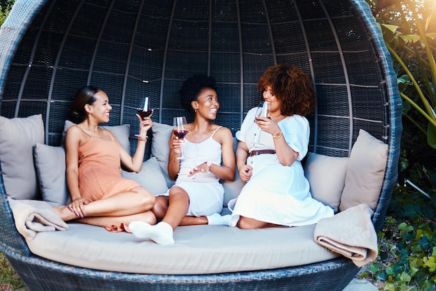 Reizen luxe en vrienden op vakantie in gesprek blij voor een uitstapje samen met alcohol wijn lachen en mensen op vacatie in de natuur binden in geluk in een moderne tent