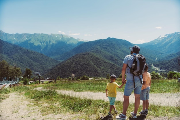 Foto reizen met kinderen man met zonen genieten van een prachtig uitzicht op de kaukasusbergen