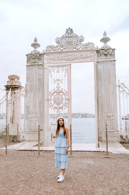 Reizen vrouw met uitzicht op dolmabahce paleis Istanbul stadslandschap drijvende toeristische boten in Bosporus, Istanbul