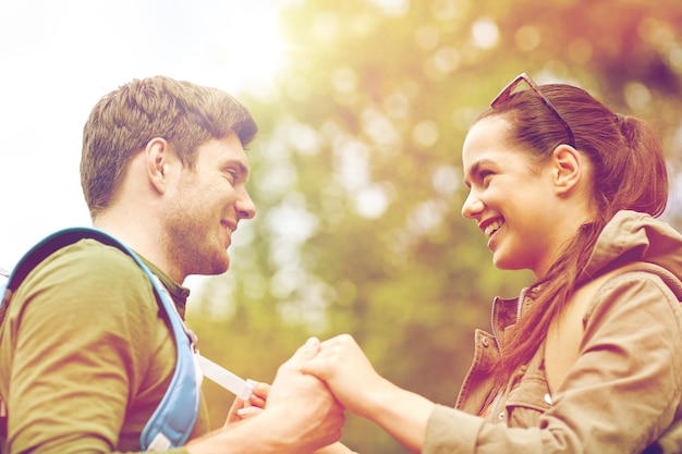 reizen, wandelen, toerisme, liefde en mensenconcept - gelukkig stel met rugzakken hand in hand buitenshuis