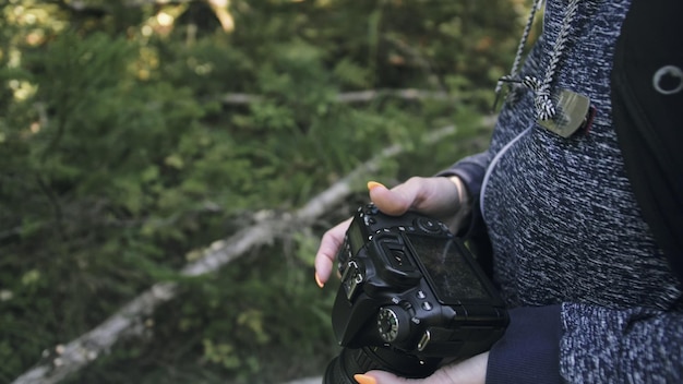 Reiziger die schilderachtig uitzicht in het bos fotografeert Een blanke vrouw die close-up kijkt Meisje neemt fotovideo op dslr spiegelloze camera
