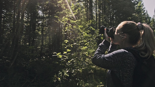 Reiziger die schilderachtig uitzicht in het bos fotografeert een blanke vrouw die een mooie magische blik fotografeert meisje neemt fotovideo op dslr spiegelloze camera