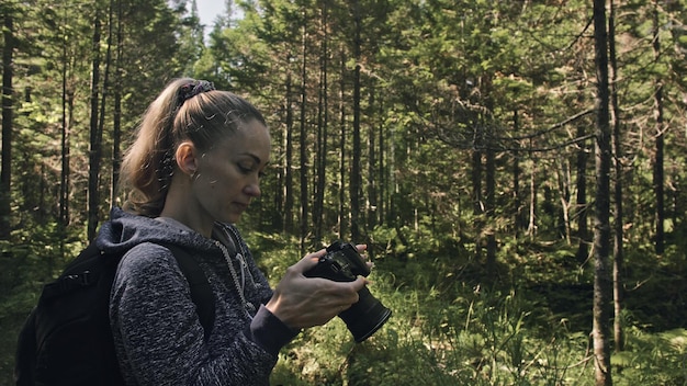 Reiziger die schilderachtig uitzicht in het bos fotografeert Een blanke vrouw die een mooie magische blik fotografeert Meisje neemt fotovideo op dslr spiegelloze camera