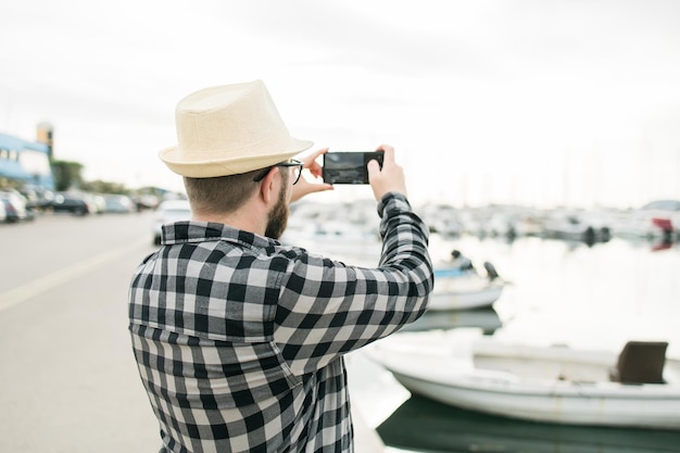 Reiziger man die foto's maakt van luxe jachten marine tijdens zonnige dag reizen en zomer concept