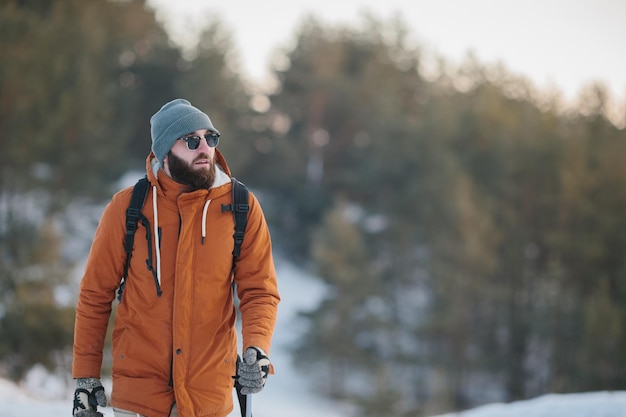 Reiziger Man met rugzak wandelen in de winter besneeuwde boslandschap Travel Lifestyle concept avontuurlijke actieve vakanties buiten koud weer in het wild