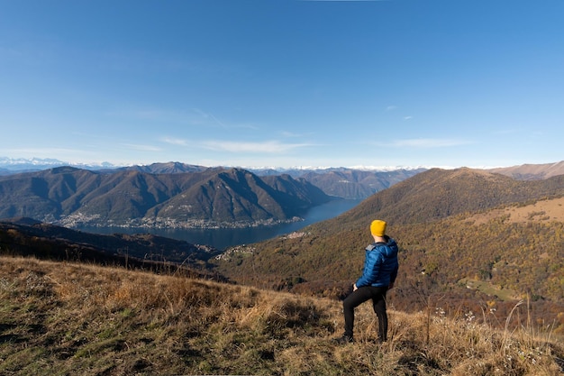 Reiziger man op de bergtop die het landschap van het comomeer italië bewondert