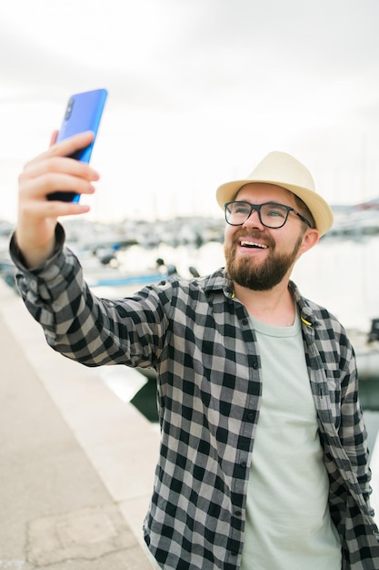 Reiziger man selfie te nemen van luxe jachten marine tijdens zonnige dag reizen en zomer concept