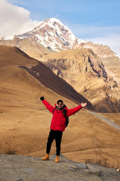 Foto reiziger met rugzak die alleen in bergachtig gebied wandelt backpacker die langs heuvelweg loopt met...