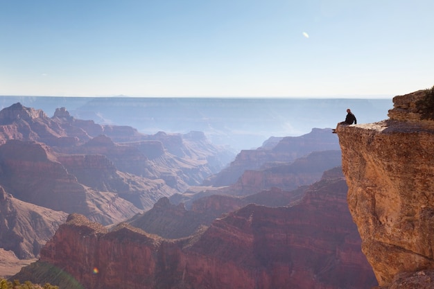 Foto reiziger op klifbergen boven het grand canyon national park, arizona, vs.inspirerende emotie. reizen lifestyle reis succes motivatie concept avontuurlijke vakanties buiten concept.