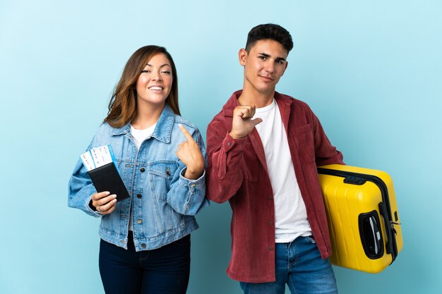 Reiziger paar met een koffer op blauw trots en zelfvoldaan in liefde jezelf concept