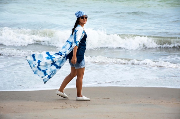 Reiziger thaise vrouwen die indigokleding dragen die eenzaam op het strand spelen en ontspannen met wind en golf bij Ban Pae-strand in Rayong Thailand