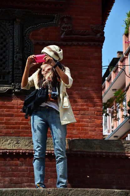 Reiziger thaise vrouwen fotograaf reisbezoek en leven en levensstijl van nepali mensen oud antiek oud gebouw in basantapur katmandu durbar square kshetra op 29 oktober 2013 in kathmandu, nepal