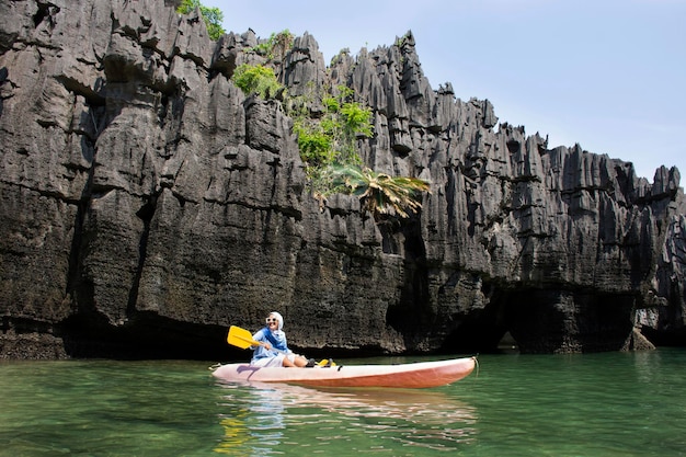 Reiziger Thaise vrouwen peddelen kano boot van lokale reis tour in zee oceaan reizen bezoek Ko Khao Yai stenen eiland en Prasat Hin Pan Yod in Mu Ko Petra National Park in Pak Bara in La ngu van Satun Thailand