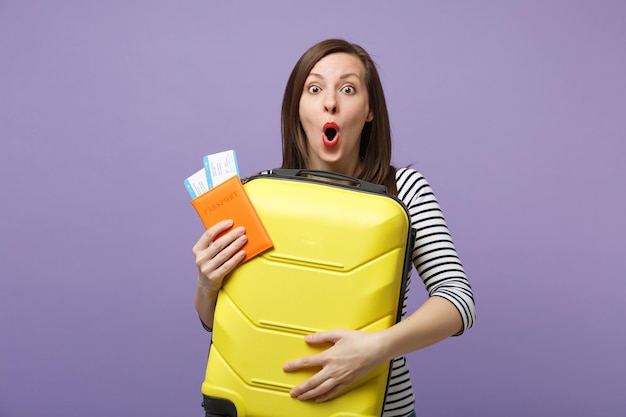 Reiziger toeristische vrouw meisje in casual gestreepte kleding poseren geïsoleerd op violet paarse achtergrond studio portret. Passagier die naar het buitenland reist om in het weekend te reizen. Lucht vlucht reis concept.