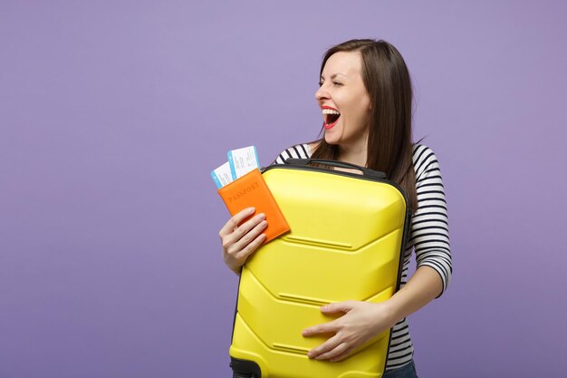 Reiziger toeristische vrouw meisje in casual gestreepte kleding poseren geïsoleerd op violet paarse achtergrond studio portret. Passagier die naar het buitenland reist om in het weekend te reizen. Lucht vlucht reis concept.