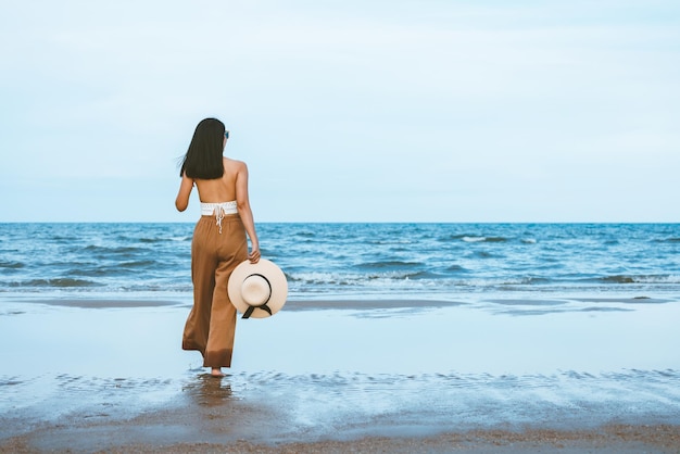 Reizigers Aziatische vrouw ontspannen en reizen op het strand in Thailand