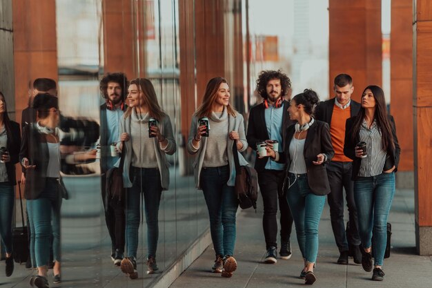 Reizigers business team van collega's lopend en pratend op moderne stedelijke stadsstraten. Mensen die niet op kantoor zijn tijdens de pauze. Hoge kwaliteit foto