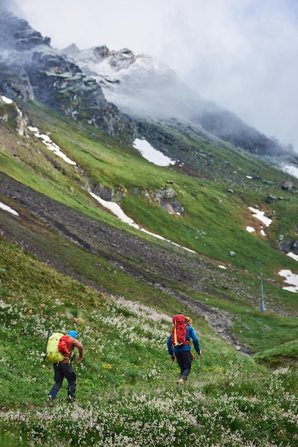 Reizigers die door de bergvallei lopen