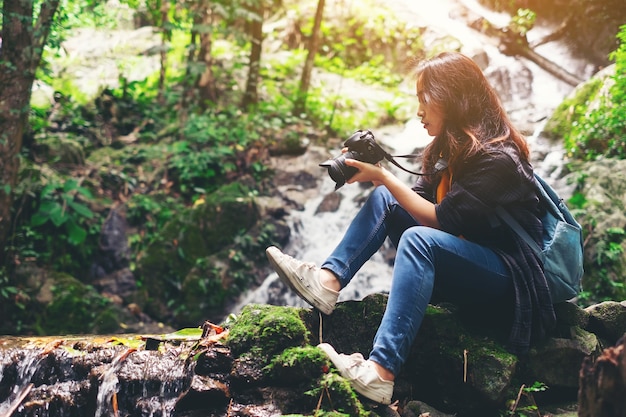 Reizigers jonge vrouw die met camera de waterval fotograferen openlucht