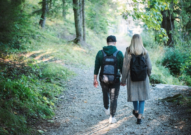 Reizigers paar verliefd genieten in het bos. Vrijheid en actieve levensstijl concept. Achteraanzicht