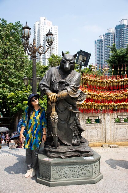 Reizigers Thaise vrouw poseren voor foto nemen met twaalf chinese dierenriem hond engel standbeeld in Wong Tai Sin tempel in Kowloon op 9 september 2018 in Hong Kong China