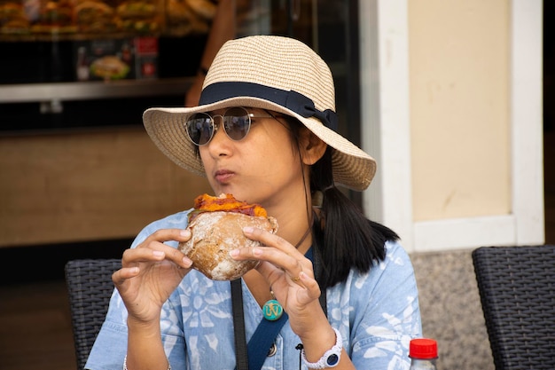 Reizigers Thaise vrouw reizen bezoeken en zitten eten sandwiches Duitse stijl serveren met frisdranken op tafel in een lokaal restaurant in Heidelberger of de oude binnenstad van Heidelberg van BadenWürttemberg Duitsland