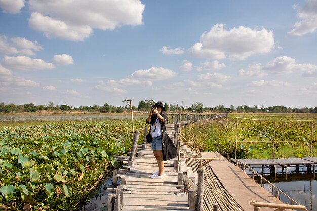 Reizigers Thaise vrouwen mensen reizen bezoeken en poseren portret voor foto nemen bij Kae Dam lange houten brug op het platteland op 11 januari 2019 in Maha Sarakham Thailand