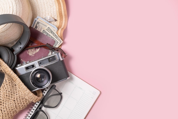 Reizigersaccessoires strandhoed met retro filmcamera zonnebril geld en paspoort in handgemaakte gebreide tas