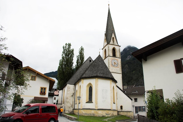 Reizigersmensen reizen en bezoeken de Lourdeskapelle-kerk en het klassieke gebouw in een klein steegje in het dorp Pfunds in de avondtijd in Tirol, Oostenrijk