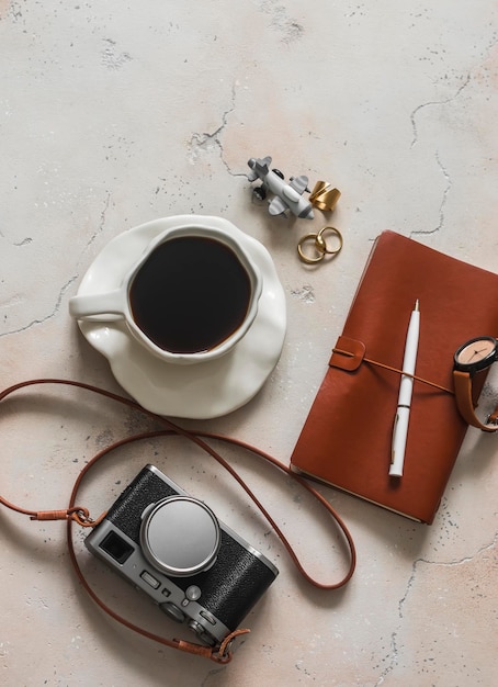 Reizigersstemming een kop koffie een retrostyle camera een notitieboek op een marmeren tafel in een café top view