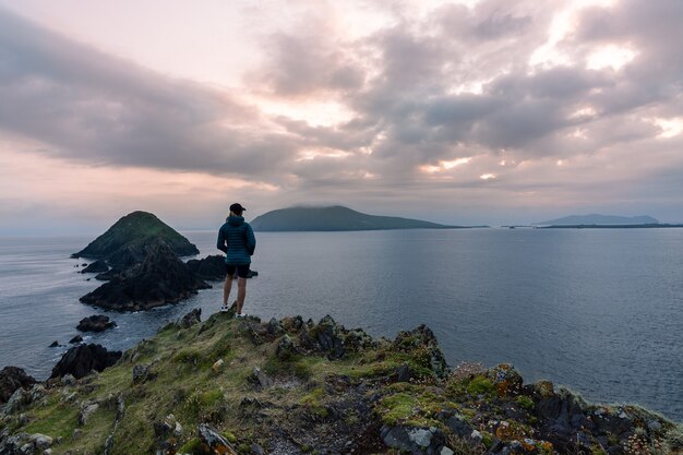 Reizigersvrouw die de zonsondergang bekijken bij Dunmore Head Dingle-schiereiland Ierland