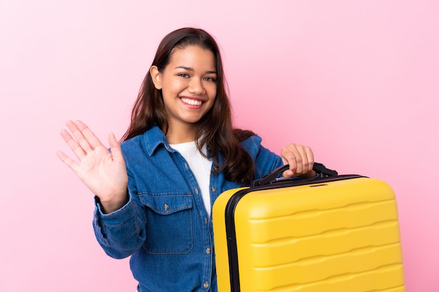 Reizigersvrouw die koffer het groeten met hand met gelukkige uitdrukking houden