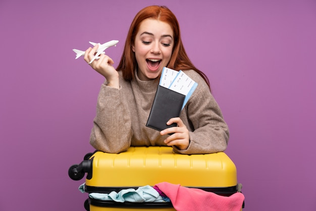 Reizigersvrouw met een koffer vol kleren en met een paspoort
