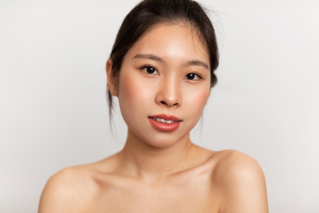 Rejuvenation concept young sensual asian woman with perfect skin posing and looking at camera over