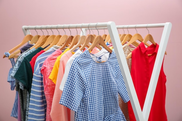 Rek met verschillende kleding in de buurt van kleurenmuur