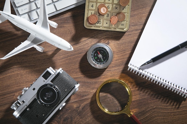 Rekenmachine, munten, retro camera, vliegtuig op de houten achtergrond.