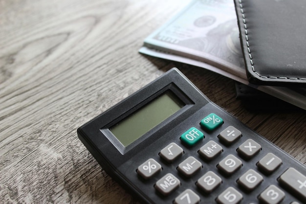 Foto rekenmachine portemonnee en geld op houten tafel met kopie ruimte zakelijk en financieel concept