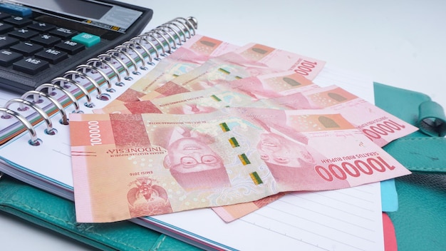 Rekenmachineboekpen en Indonesische roepia-bankbiljetten Selectieve focus