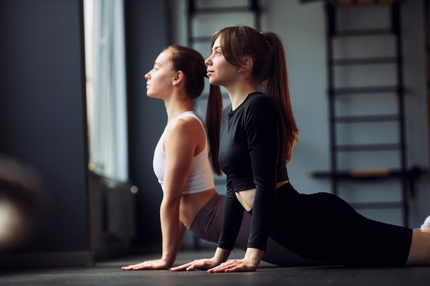 Rekoefeningen doen Twee vrouwen in sportieve kleding hebben samen een fitnessdag in de sportschool