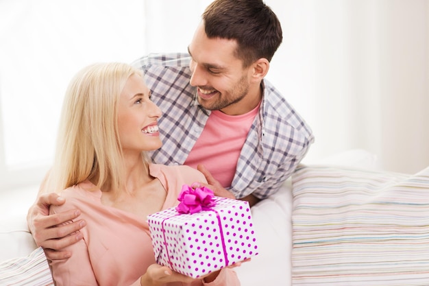 relaties, liefde, mensen, verjaardag en feestdagen concept - gelukkige man die vrouw cadeaudoos thuis geeft
