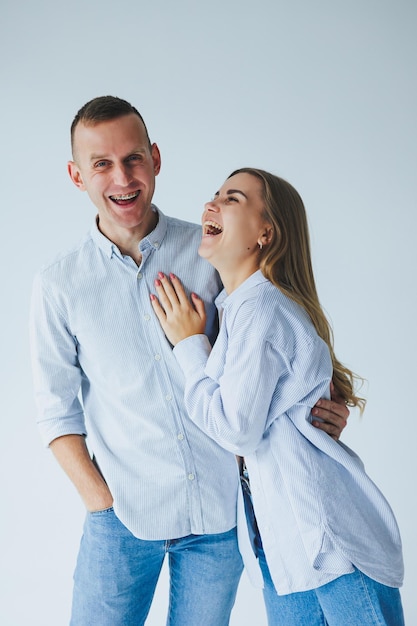 Foto foto del concetto di relazione di una coppia felice in camicie bianche e jeans su sfondo bianco felice giovane coppia