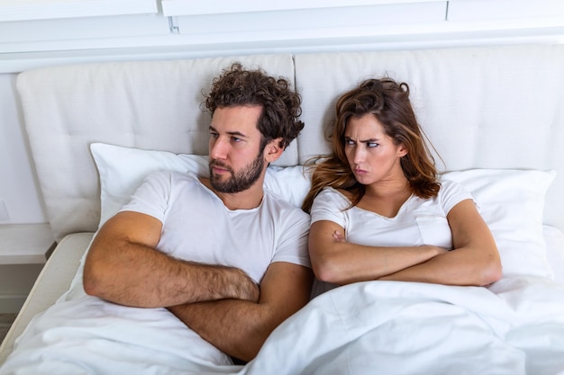 Relationship concept. Top view of young couple lying on the bed. Couple having a fight in the bed. concept about relationship and problems between couples. Sexual frustration. Lovers ignore each other