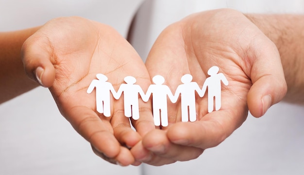 relationships and love concept - closeup of couple hands showing paper cutout team