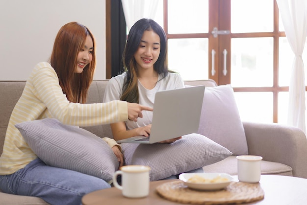 Relax at home concept Lesbian couple pointing on laptop and typing data while working together