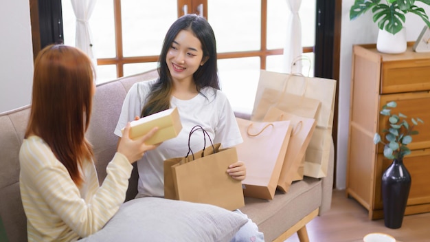 Relax at home concept LGBT lesbian female is smiling while receiving gift box from girlfriend