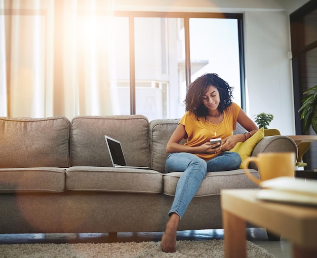 Relax home and woman with a smartphone typing and connection with social media communication and digital chatting Female person laptop and girl on a couch cellphone and mobile app for texting